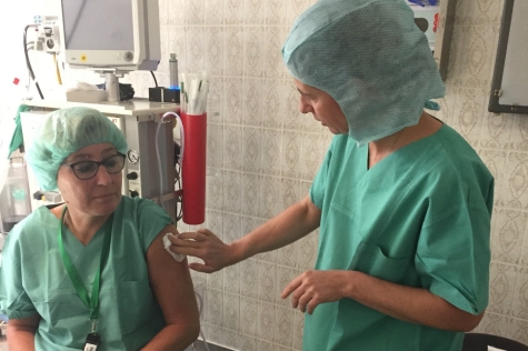 Eine Frau wird beim Arzt von einer Ärztin geimpft.
